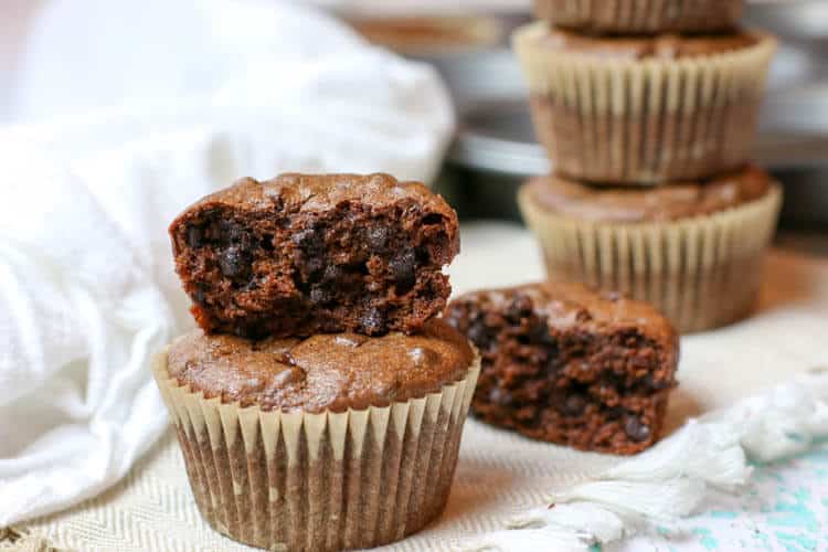 Half eaten double chocolate muffin that is gluten free and sweetened with banana.