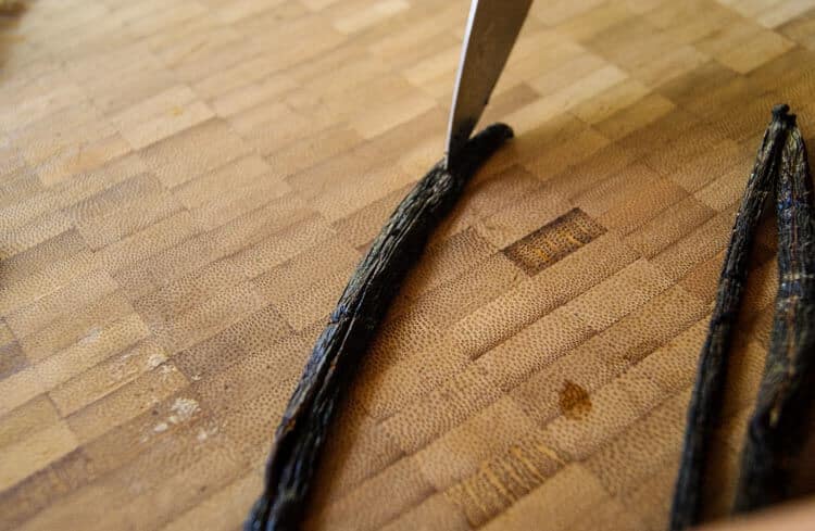 Vanilla bean with a knife slicing down the middle
