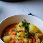 Chicken stew in a bowl with Instant Pot in the background