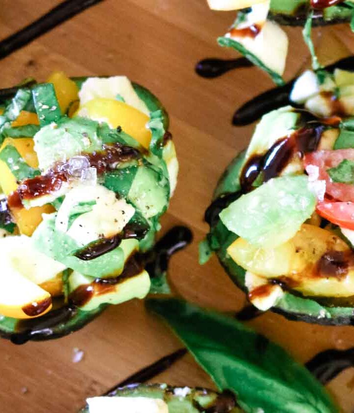 Caprese Stuffed Avocados with mozzarella and grape tomatoes and fresh basil.