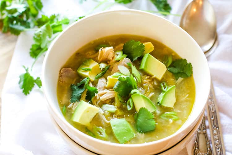 Chicken chili with healthy toppings like avocado, cilantro, green onions