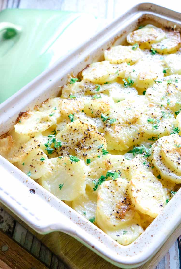 Scalloped potatoes over chicken in a casserole dish