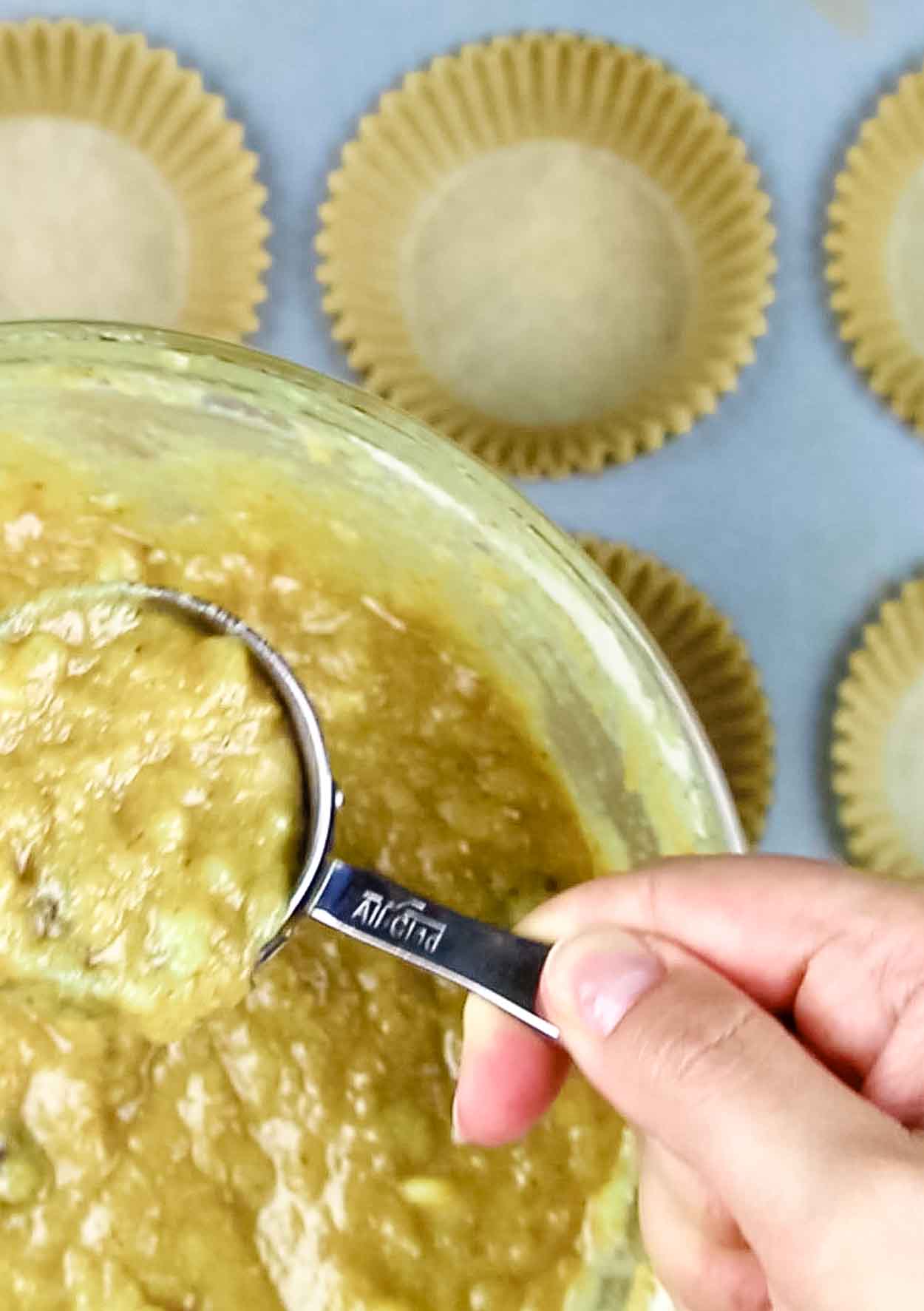 bowl of paleo banana bread batter that is scooped up for muffin baking