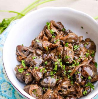 Creamed mushrooms with onions and red wine in a small serving bowl