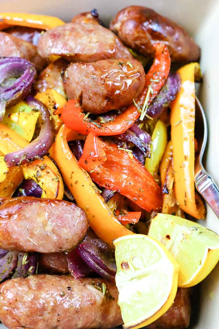 Baked in the oven sausages, bell peppers, onions, and lemon wedges