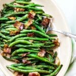 Green beans with bacon on a platter with a serving spoon