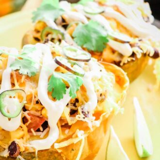 Roasted and Stuffed Acorn Squash with drizzle of sour cream, cilantro and jalapeno