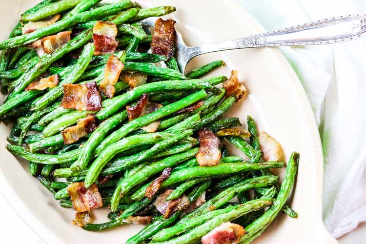 Green beans with crunchy bacon pieces in a serving platter