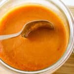 Homemade Buffalo Wing sauce in a small jar with a spoon