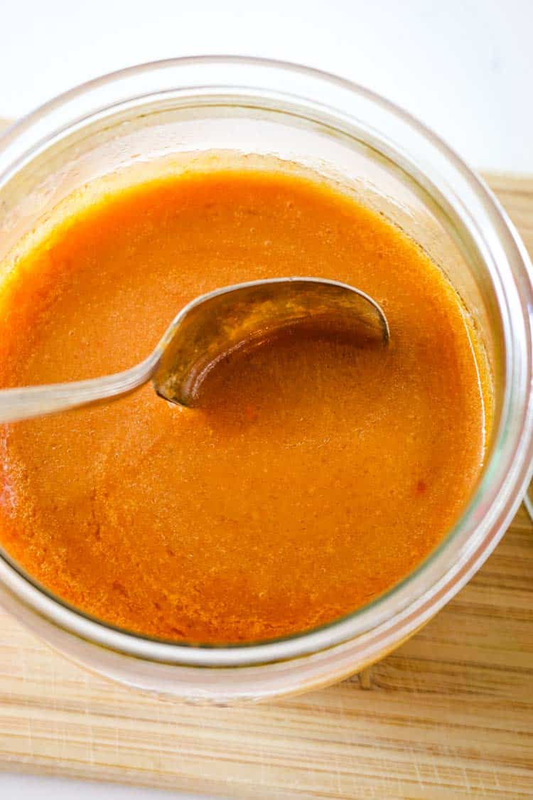 Homemade Buffalo Wing sauce in a small jar with a spoon