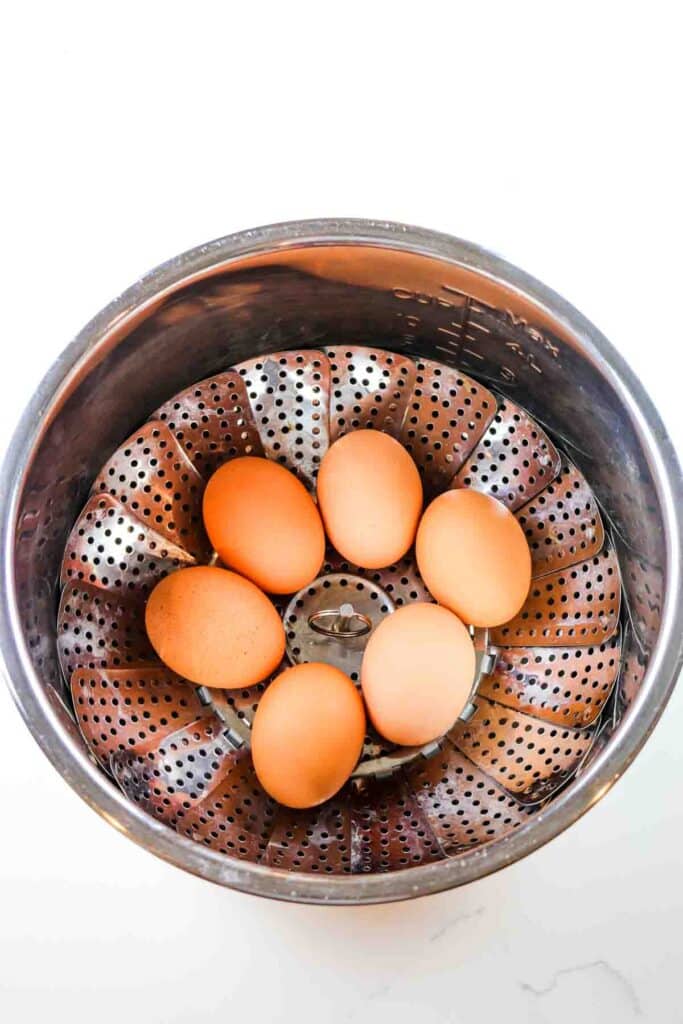 Six eggs in a steamer basket in an instant Pot liner.