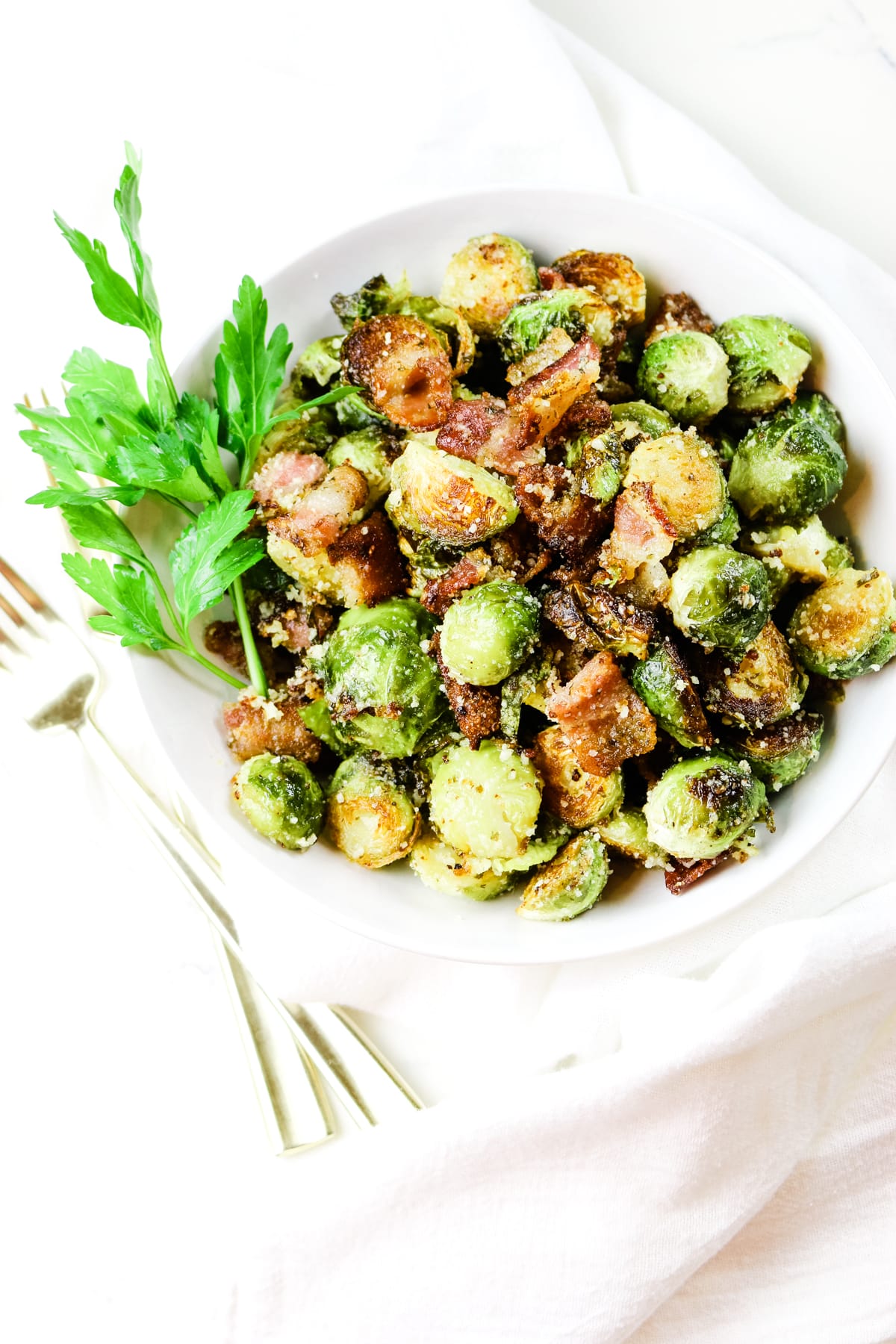 Roasted Brussels sprouts with bacon in a white bowl