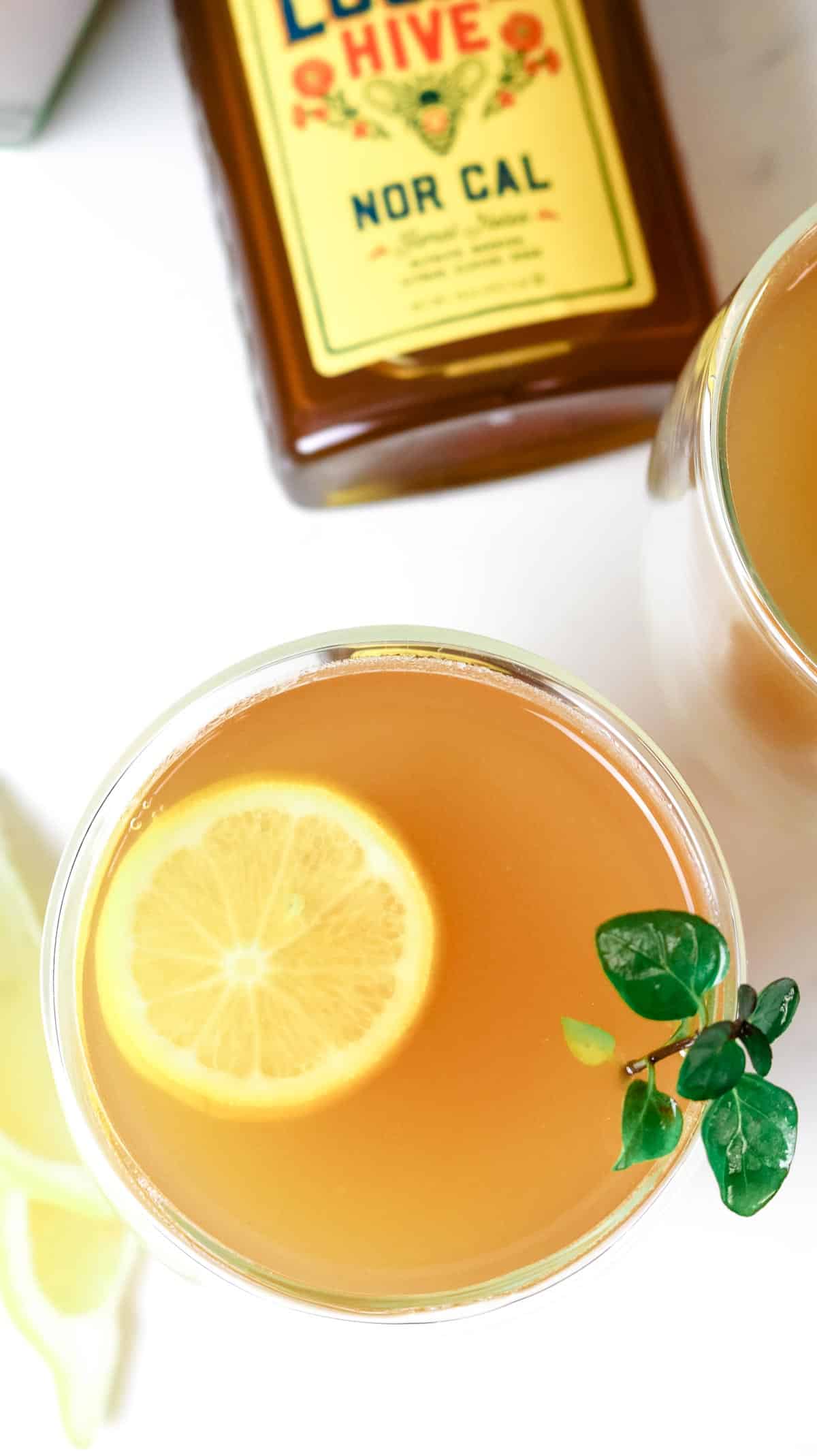 Honey Citrus Mint Tea in mug with bottle of honey peeking through