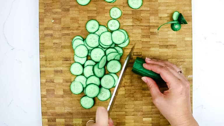Slicing cucumber into small discs.
