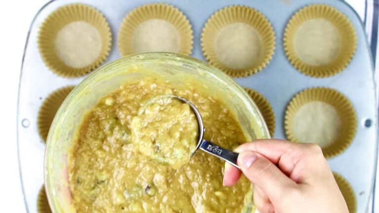 Coconut flour banana bread batter is spooned into muffin tin