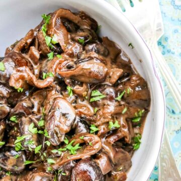 Creamed Mushrooms in a small bowl with garnished parsley