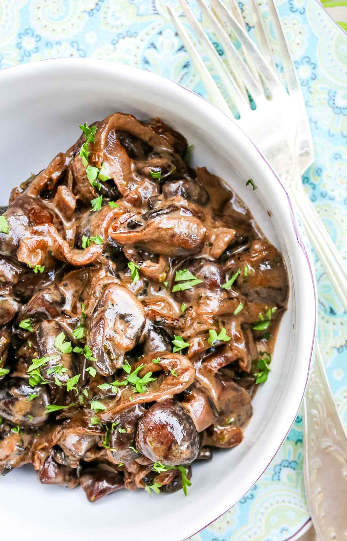 Creamed Mushrooms in a small bowl with garnished parsley