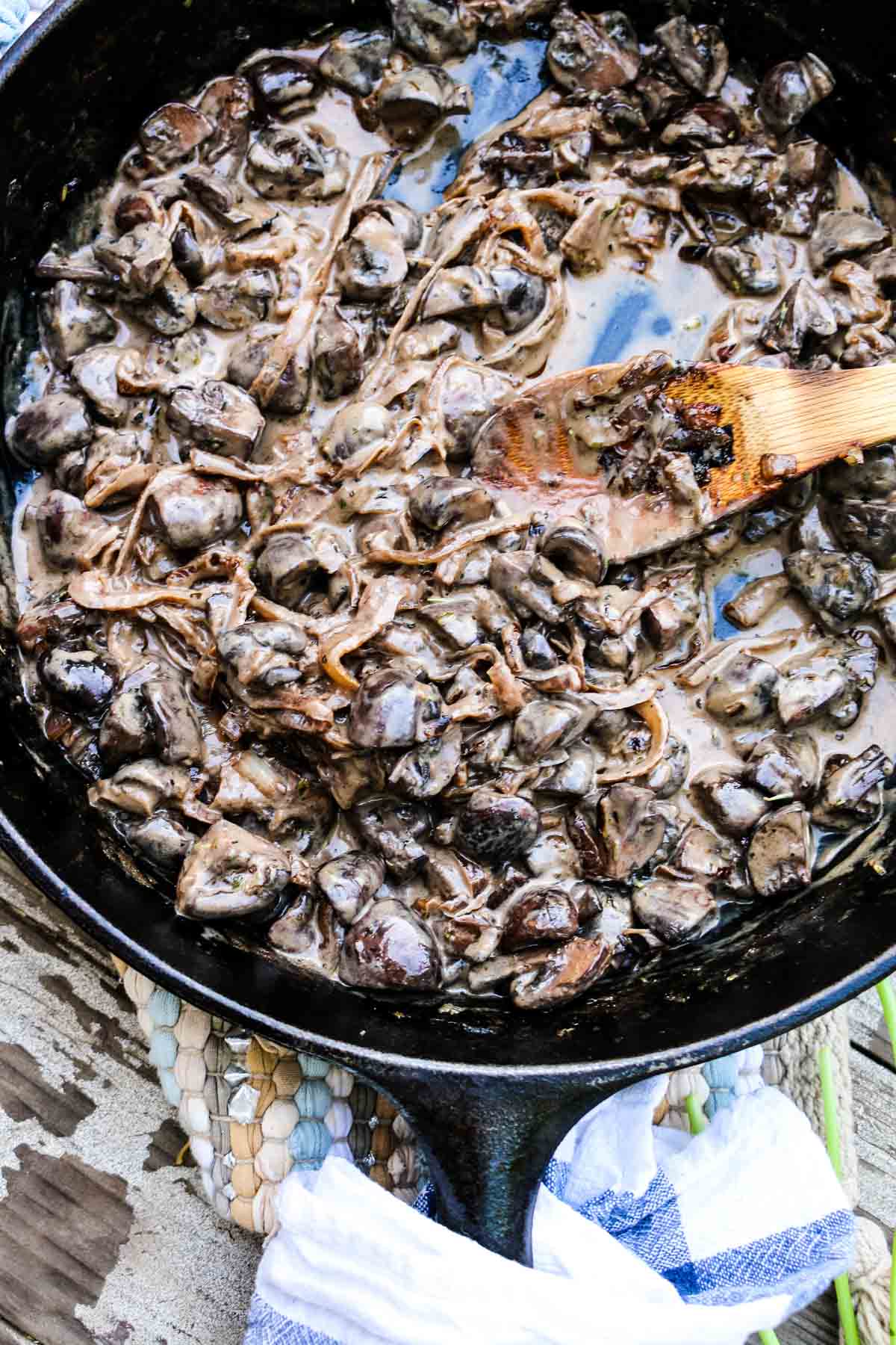 Creamy Mushrooms in a cast iron skillet with a wooden spoon