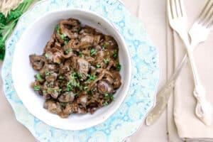 Creamed Mushrooms in a floral bowl and plate with two forks to the side