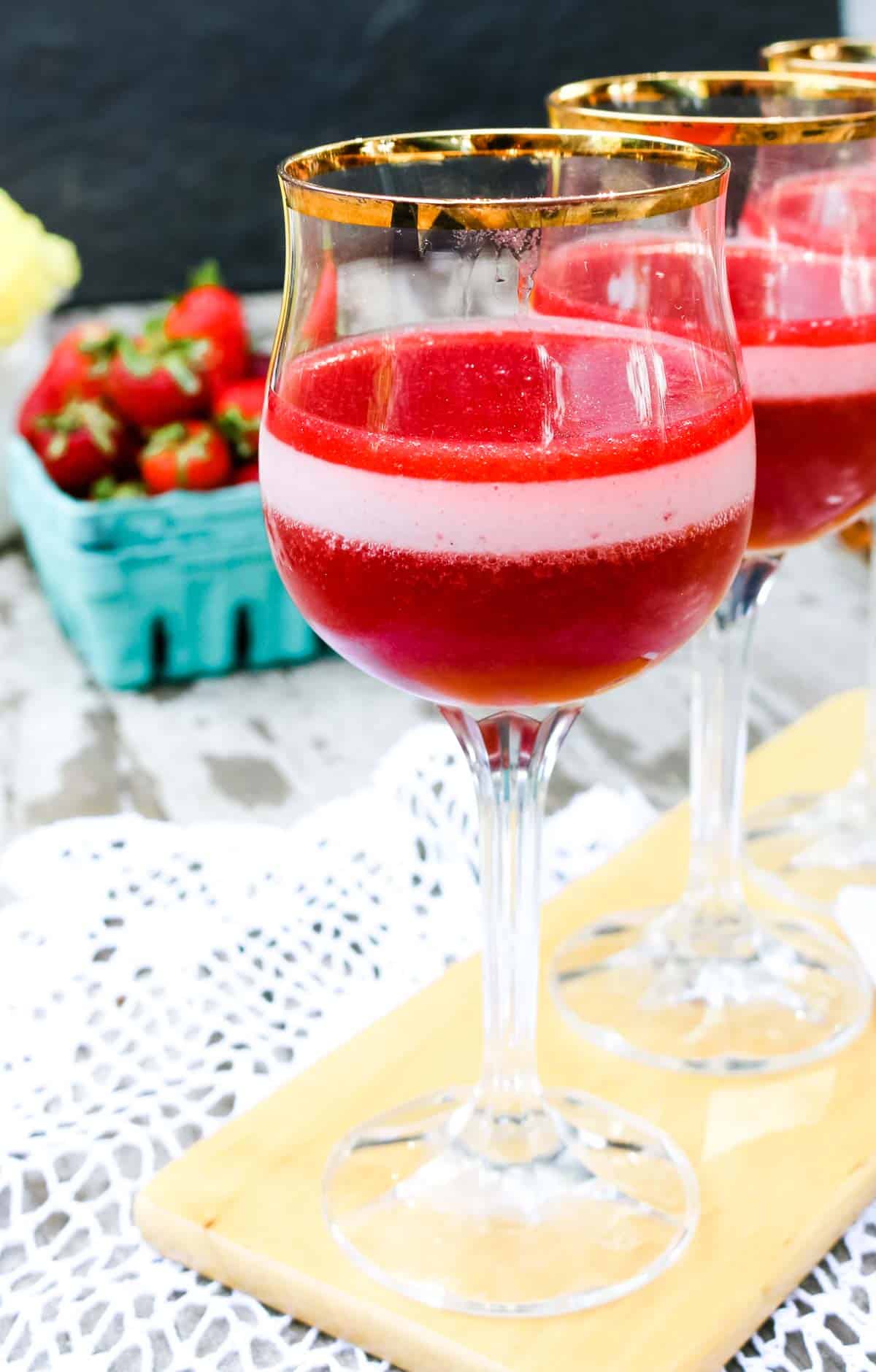 Homemade strawberry jello and cream-yogurt gelatin in the middle layer in a wine glass. 