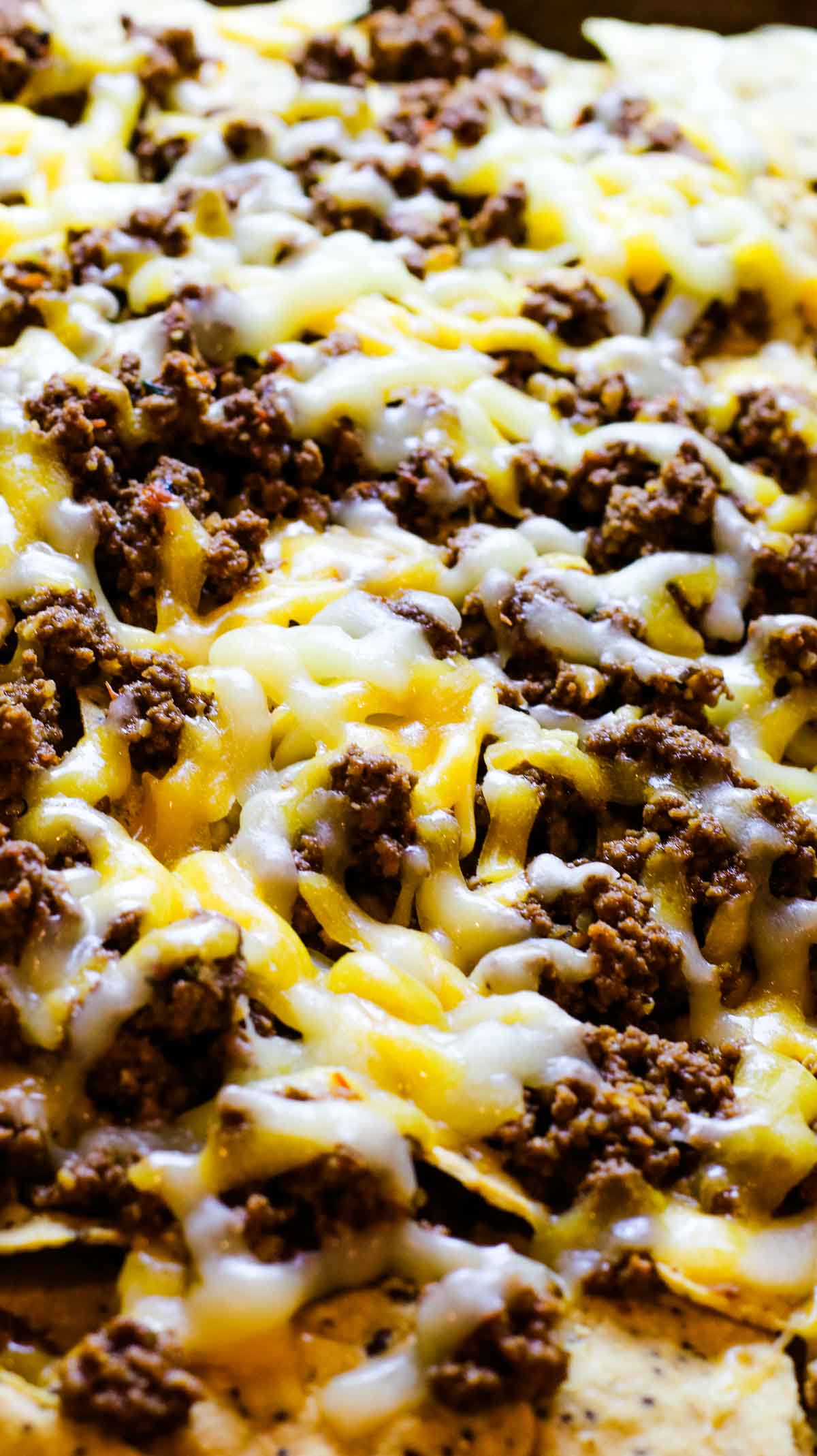 image of taco meat and melted cheese on top of tortilla chips