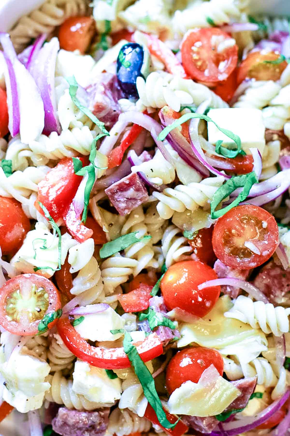 red onions, olives, feta and tomatoes in pasta salad