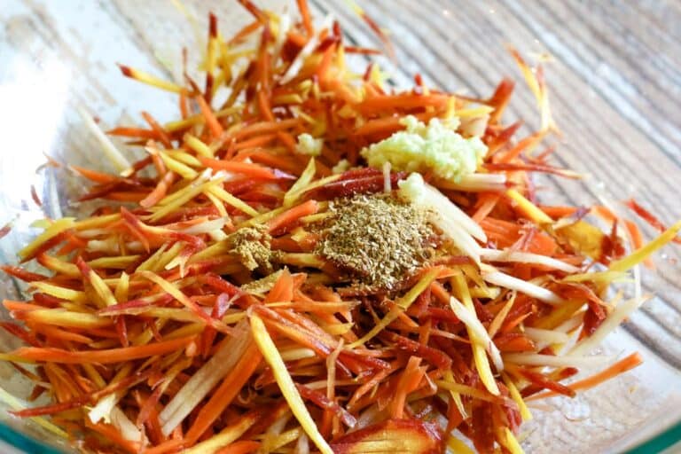 shredded carrots with coriander, garlic, and cumin in a bowl