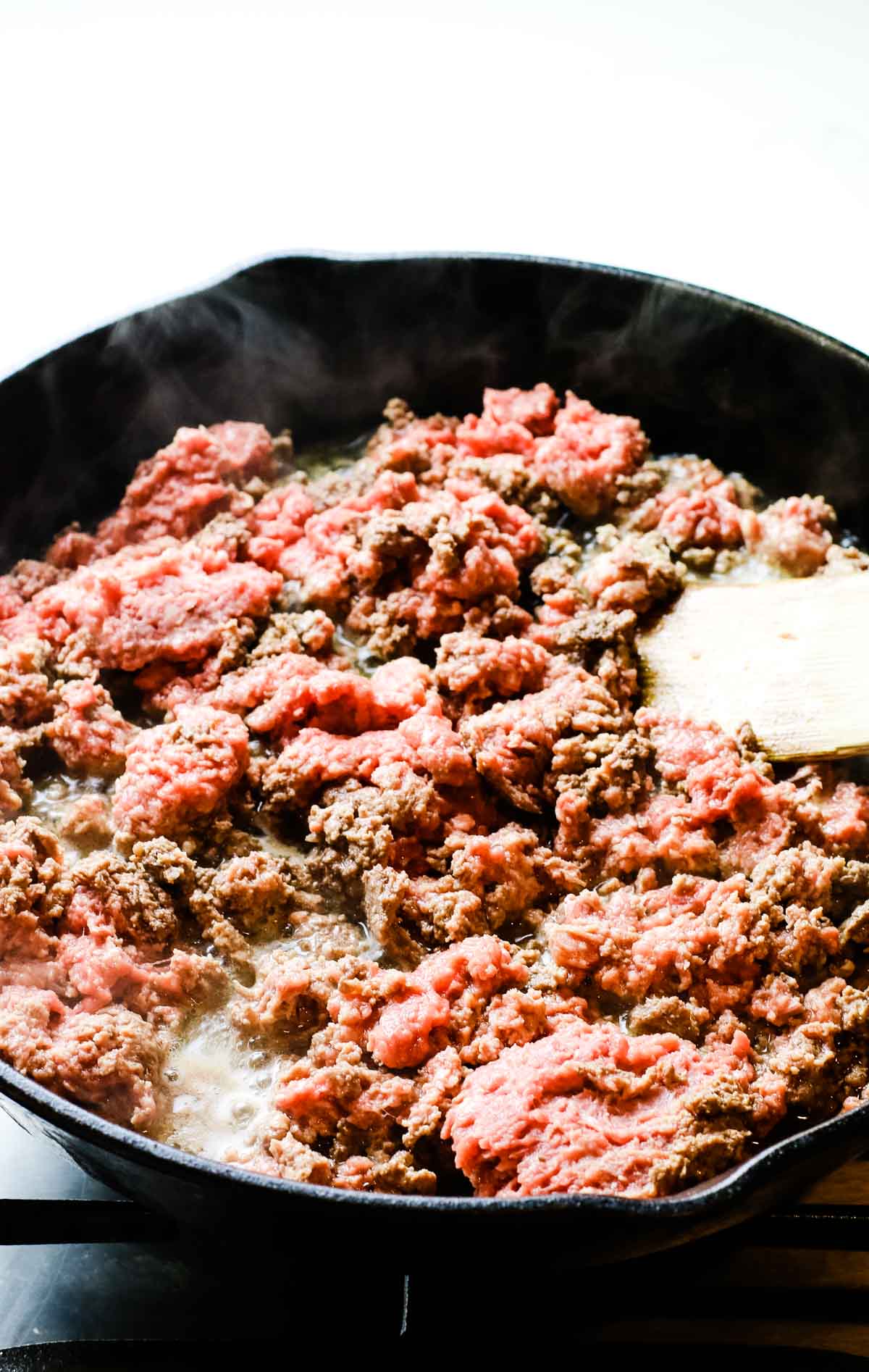 Ground meat in a cast iron skillet slightly cooked