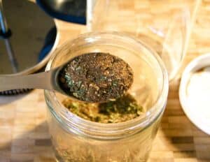 herbal coffee blend in a large jar with a spoon