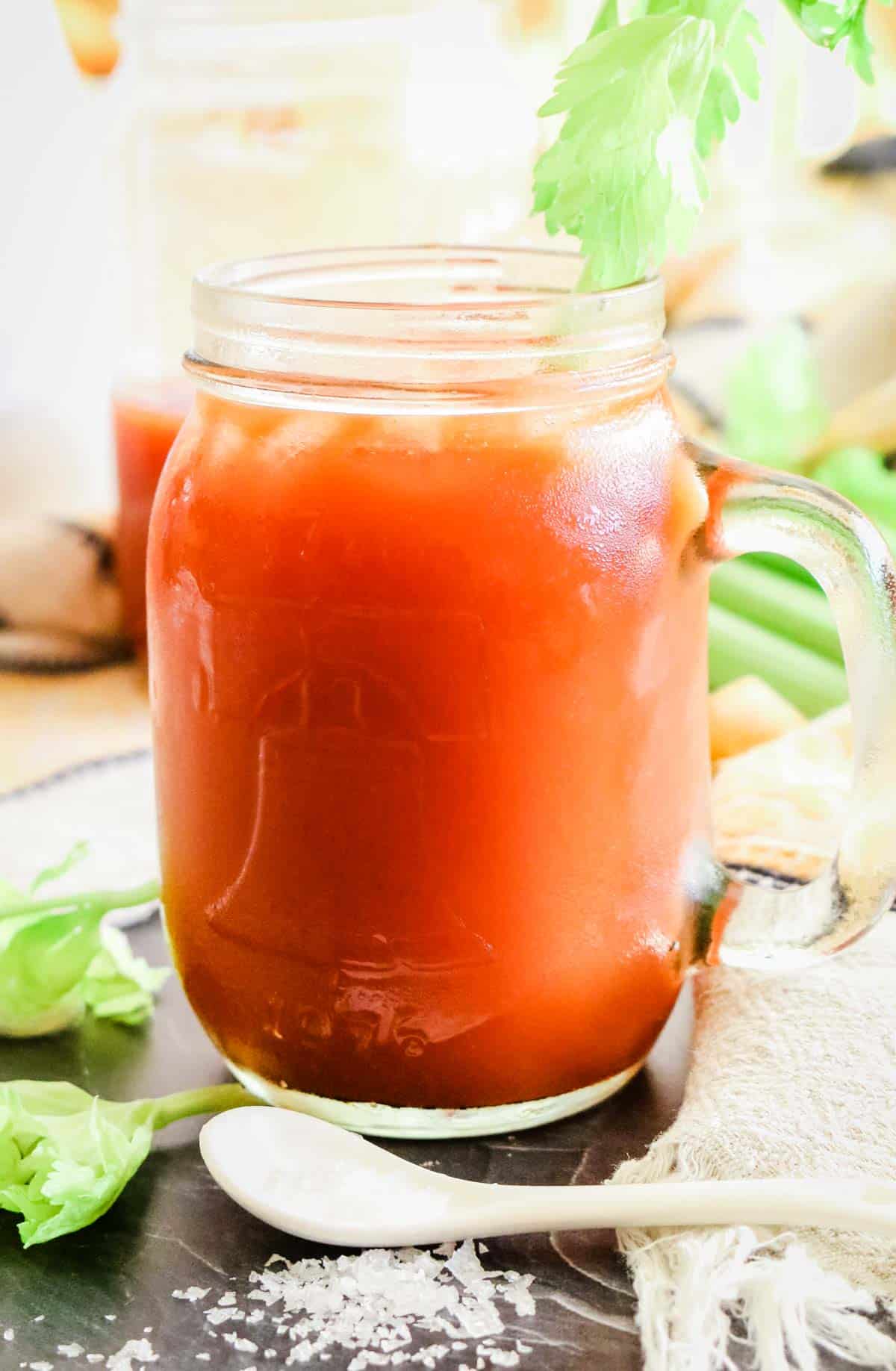 tomato juice in a small mason jar with celery rib