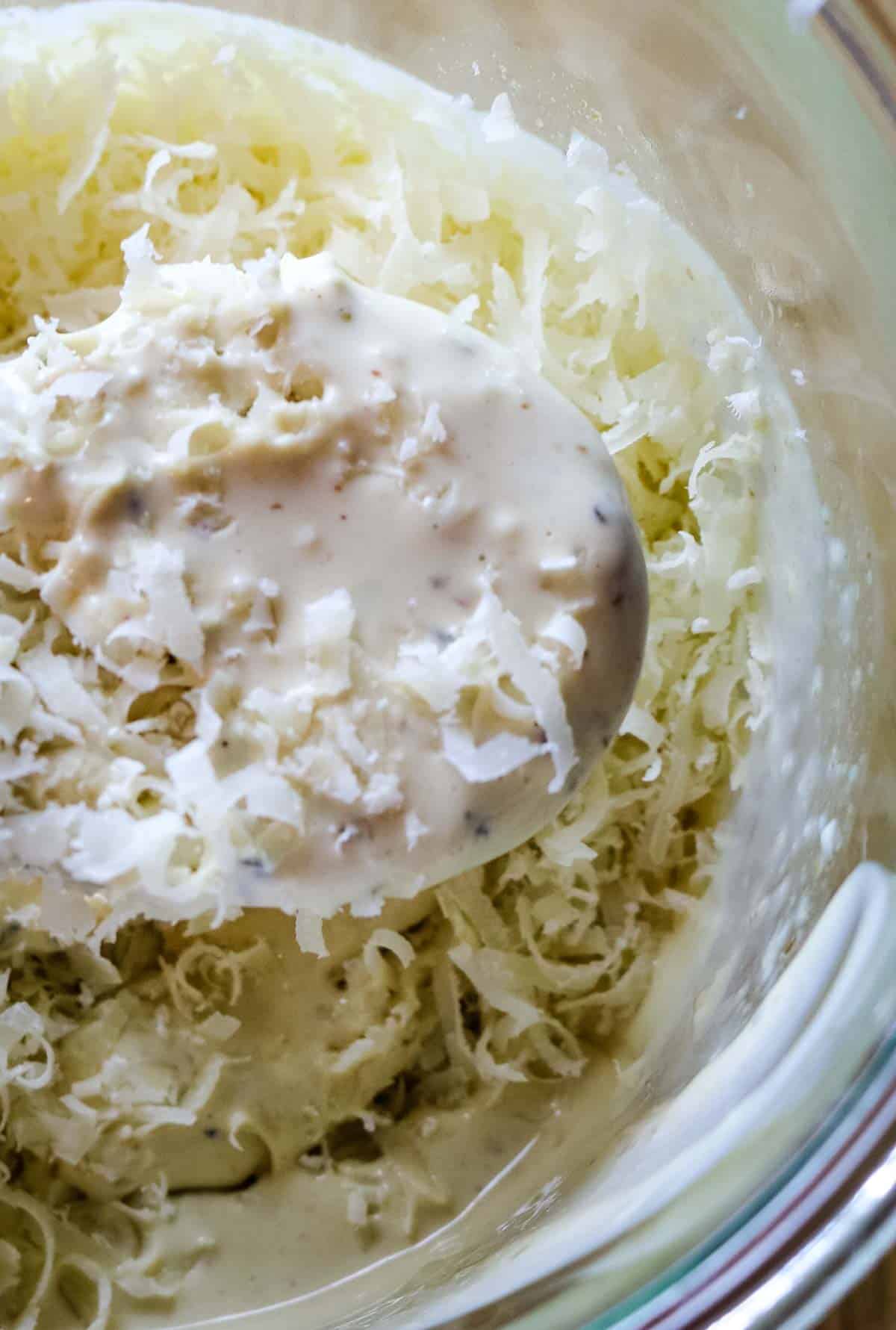Caesar Salad dressing on a spoon with parmesan cheese