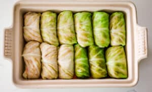 twelve cabbage rolls in single layer in casserole dish