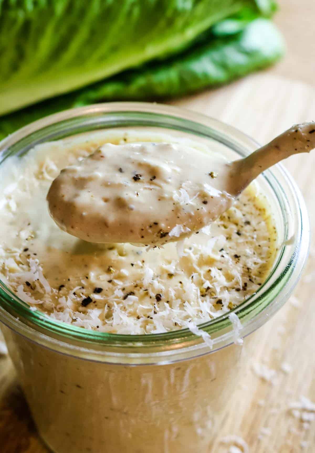 homemade Caesar salad dressing in a jar with a spoon