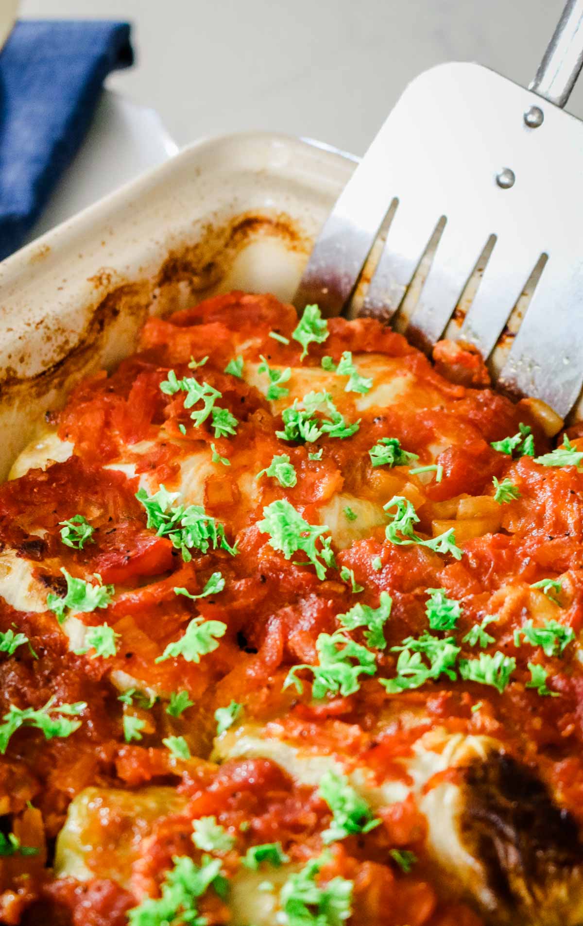 cabbage rolls in a baking dish with a spatula