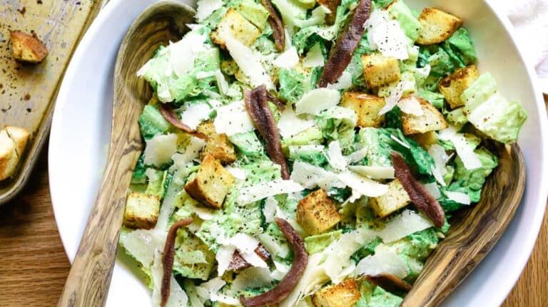 homemade caesar salad in a large white salad bowl