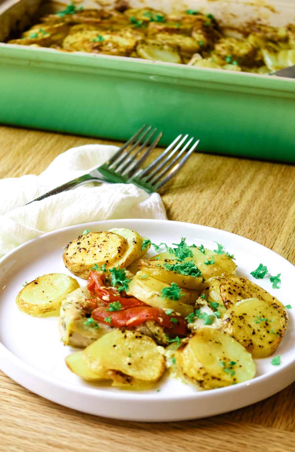 scalloped potatoes with chicken and tomateos on plate