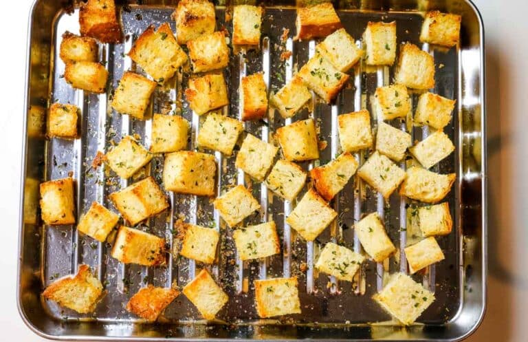 golden brown croutons on a stainless steel sheet pan.