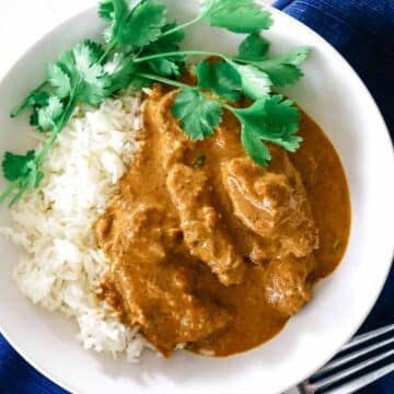 white bowl with butter chicken and cilantro