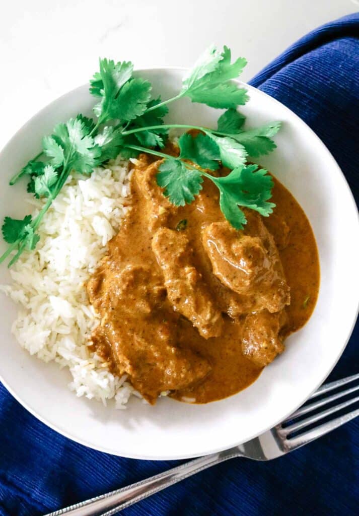 white bowl with butter chicken and cilantro