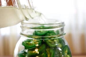 pouring salty brine over jalapenos