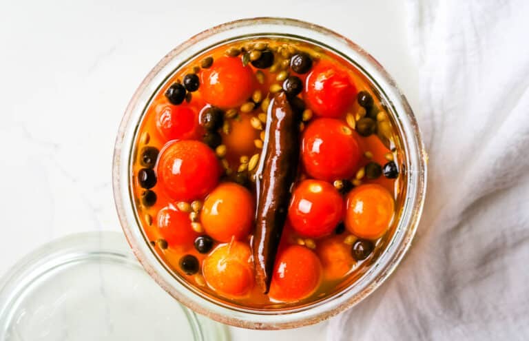 cherry tomatoes submerged in brine in weck jar.