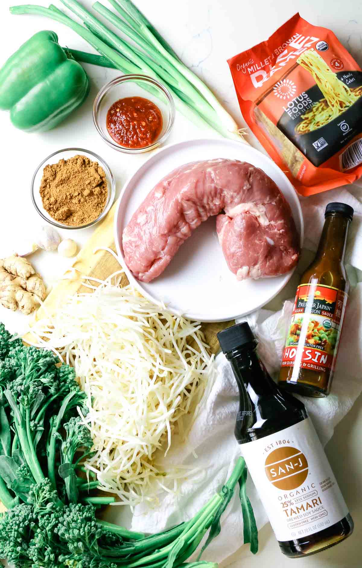 flat lay of spicy pork ingredients with pork tenderloin, broccoli, tamari, and more.