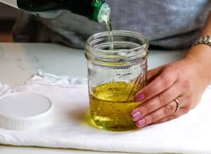 Pouring oil into jar.