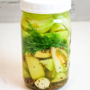 green tomatoes with fresh dill in mason jar.