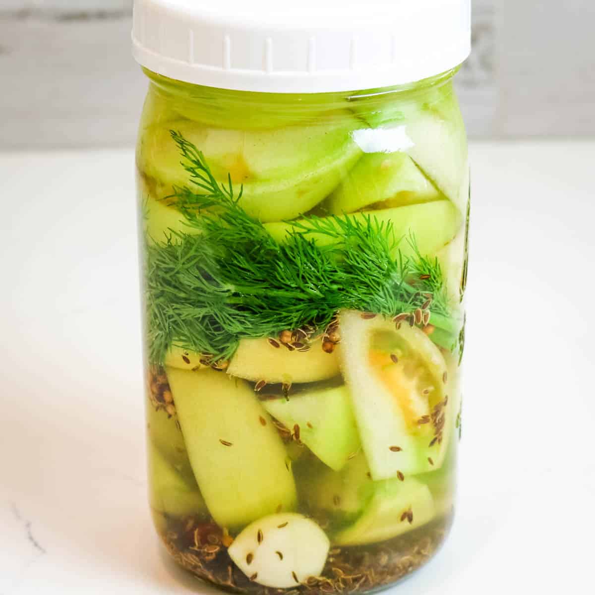 https://prepareandnourish.com/wp-content/uploads/2022/09/green-tomatoes-in-mason-jar-with-plastic-lid.jpg