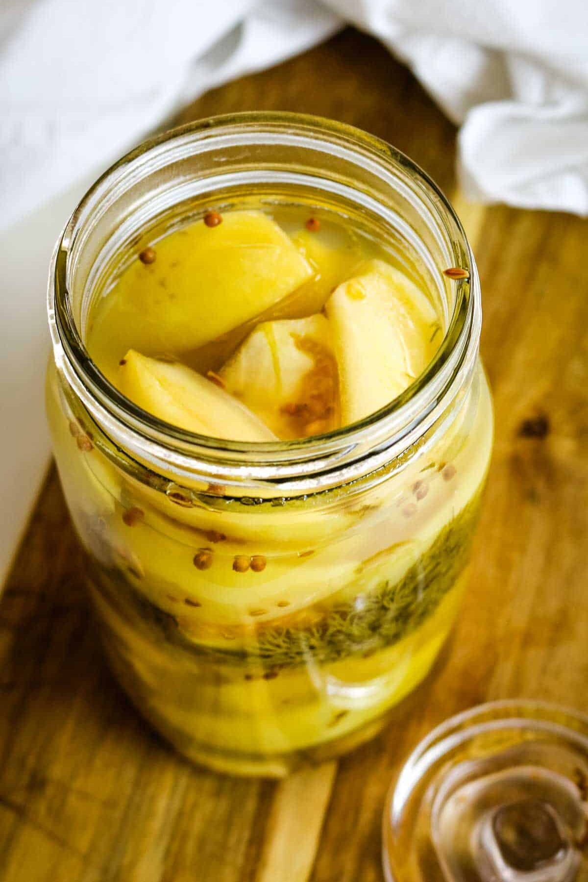 green tomatoes in a mason jar with brine.