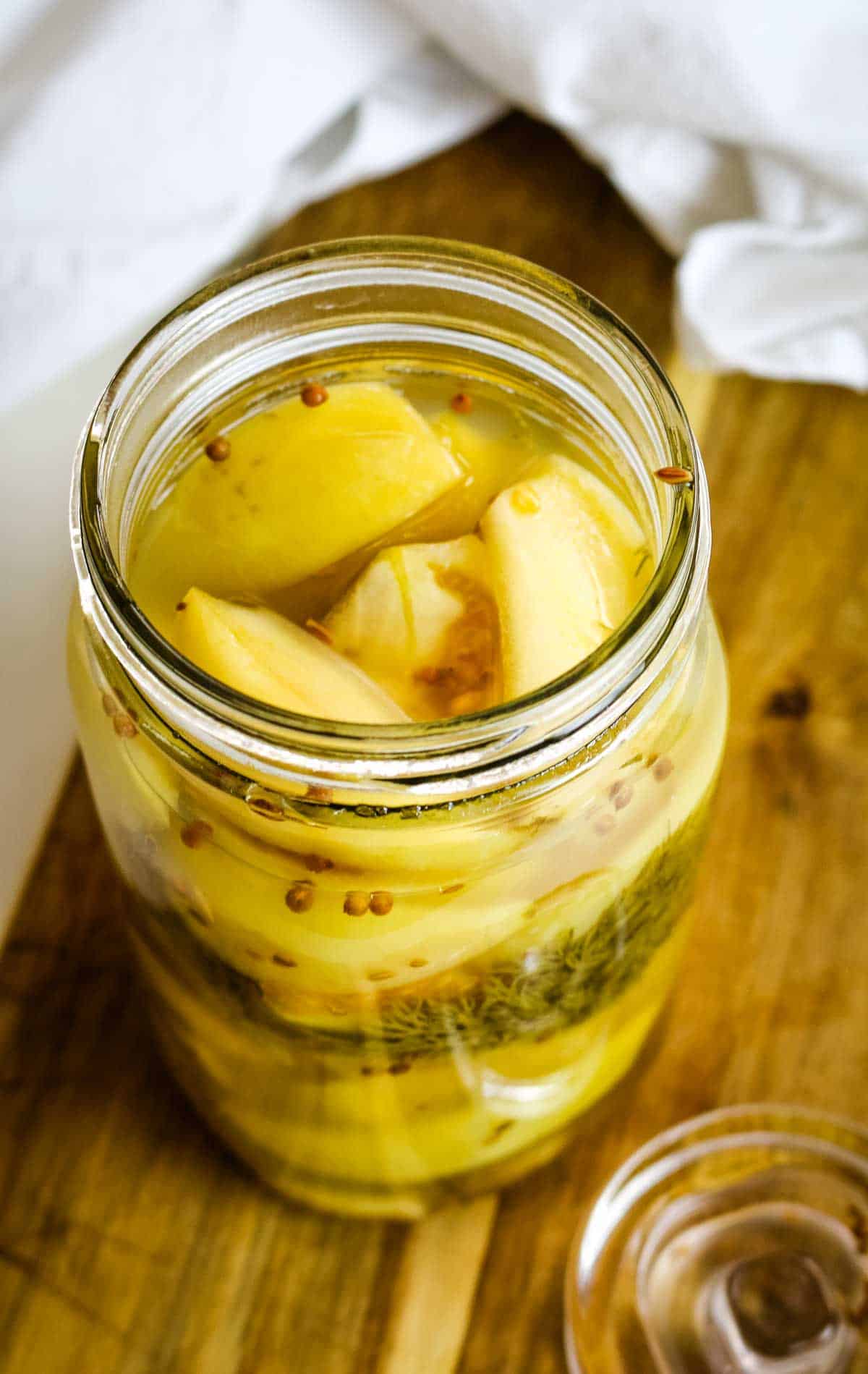 green tomatoes in a mason jar with brine.