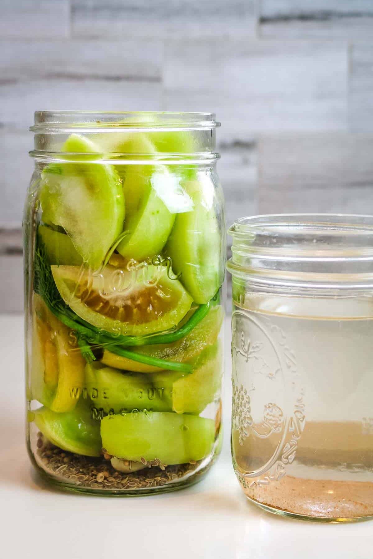 packed green tomatoes in a mason jar.