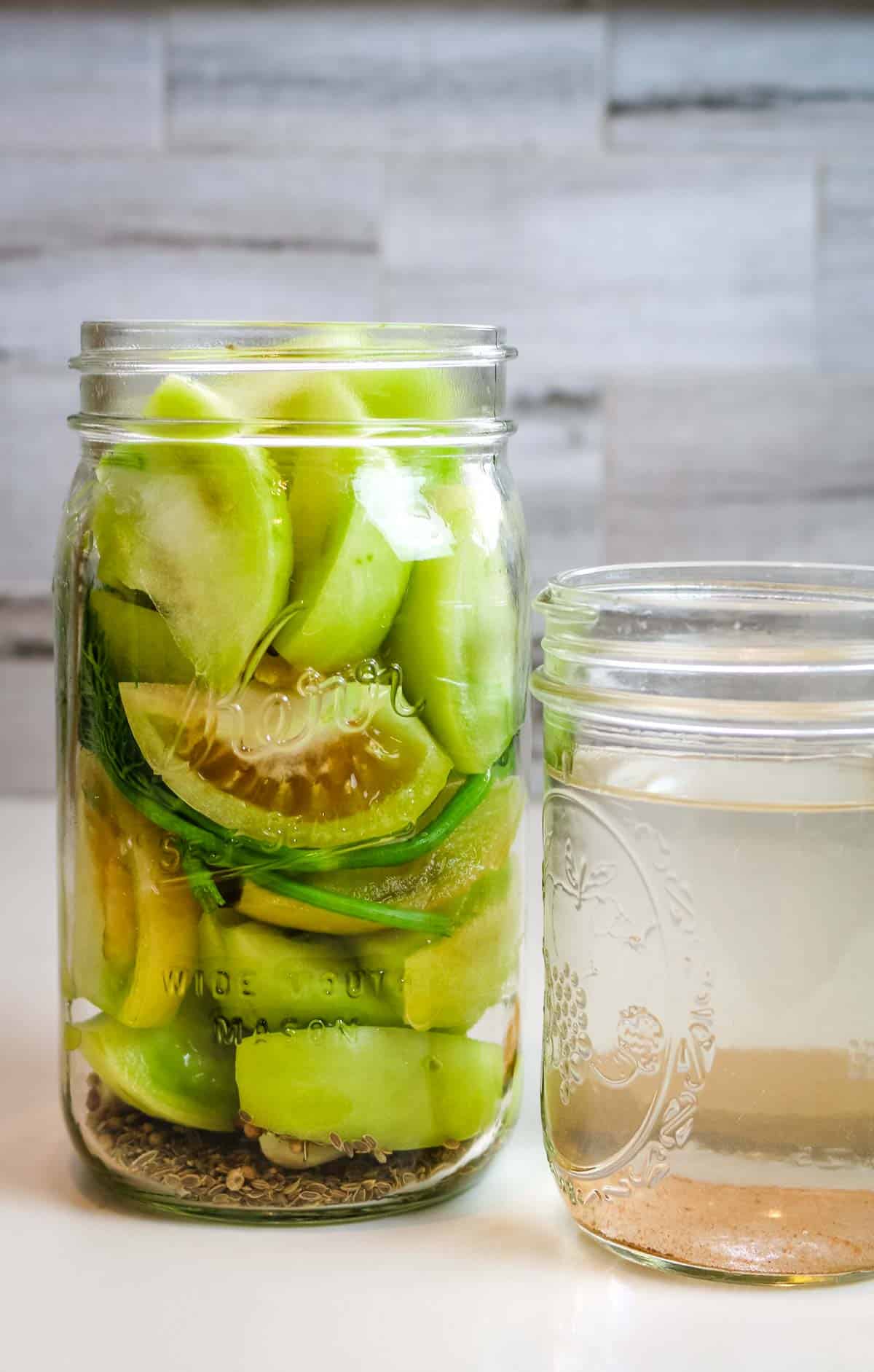 packed green tomatoes in a mason jar.