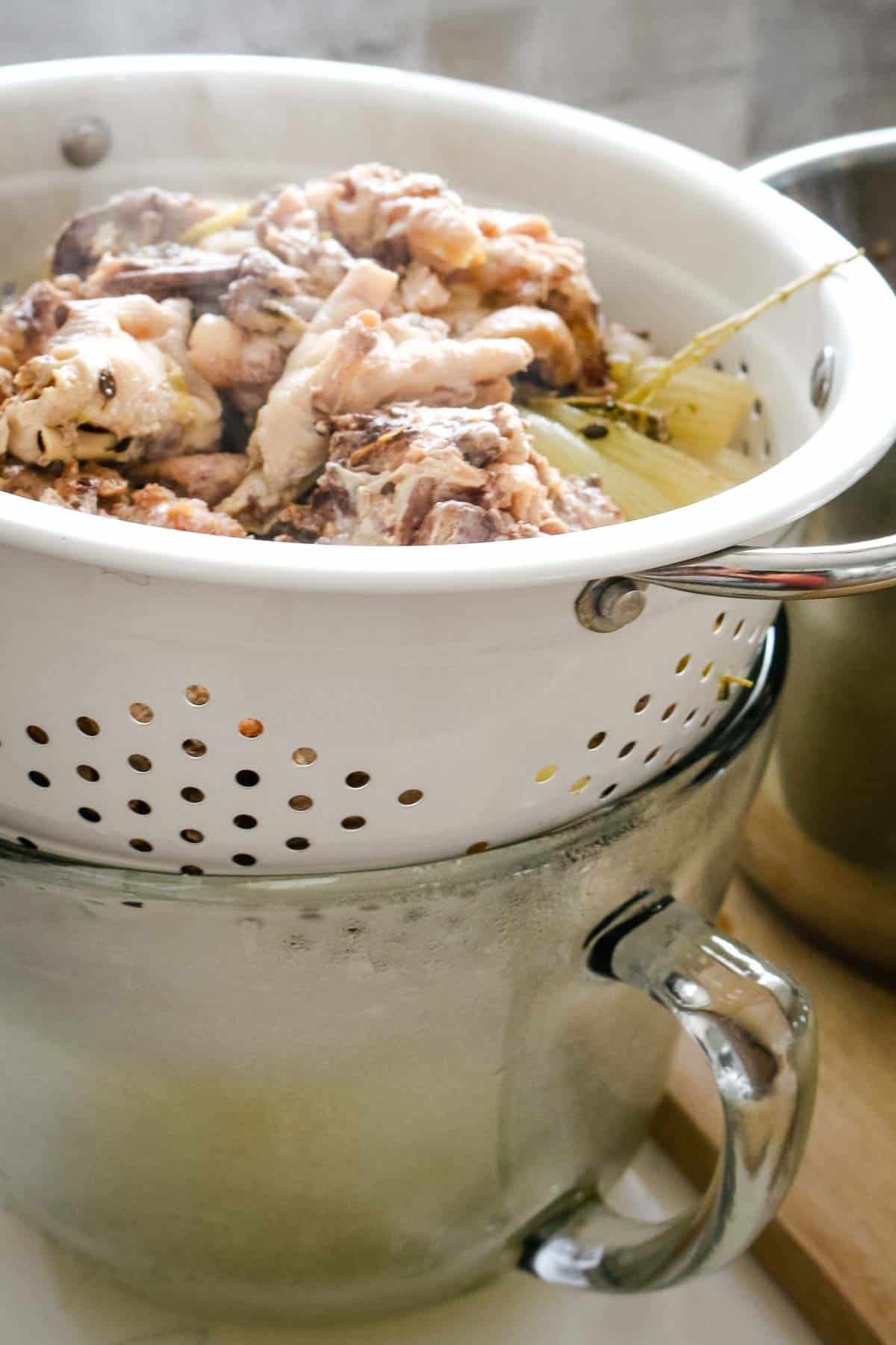 collecting meat and bones in colander for bone broth.